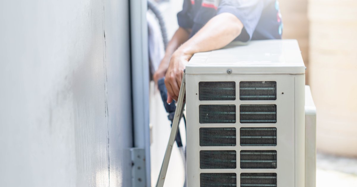 A professional HVAC contractor separates a unit from a building to clean the air conditioner components.